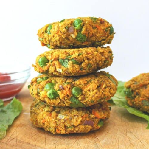 Four quinoa chickpea curry patties stacked on top of each other.