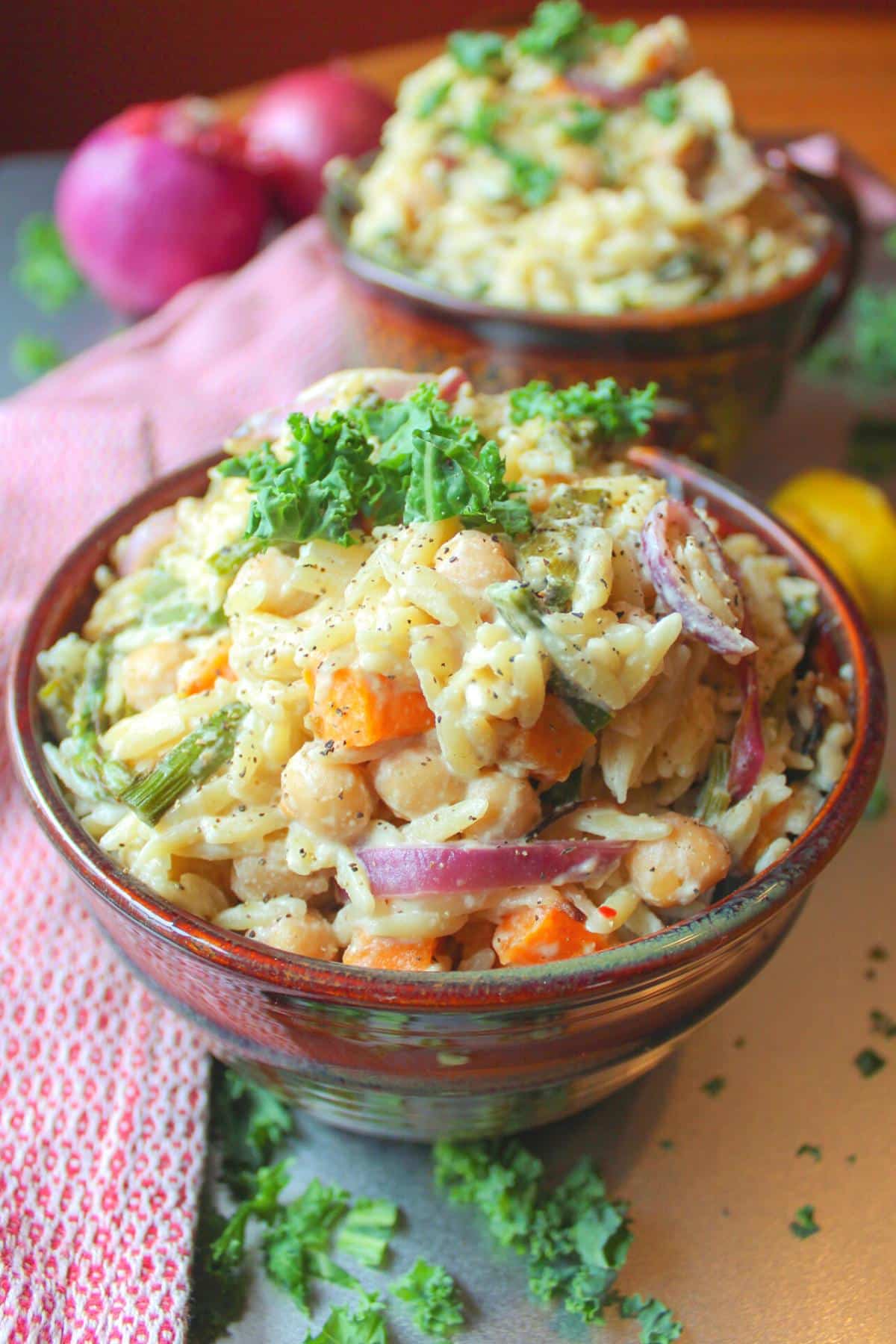 A bowl of creamy vegan orzo with roasted vegetables.
