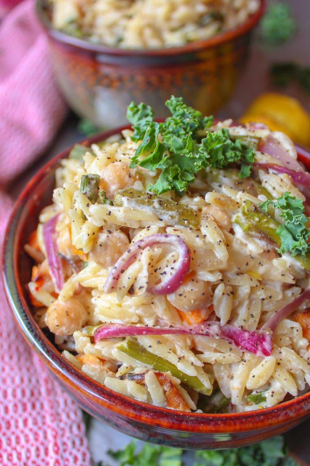 Orzo with cashew cream in a bowl with roasted vegetables.