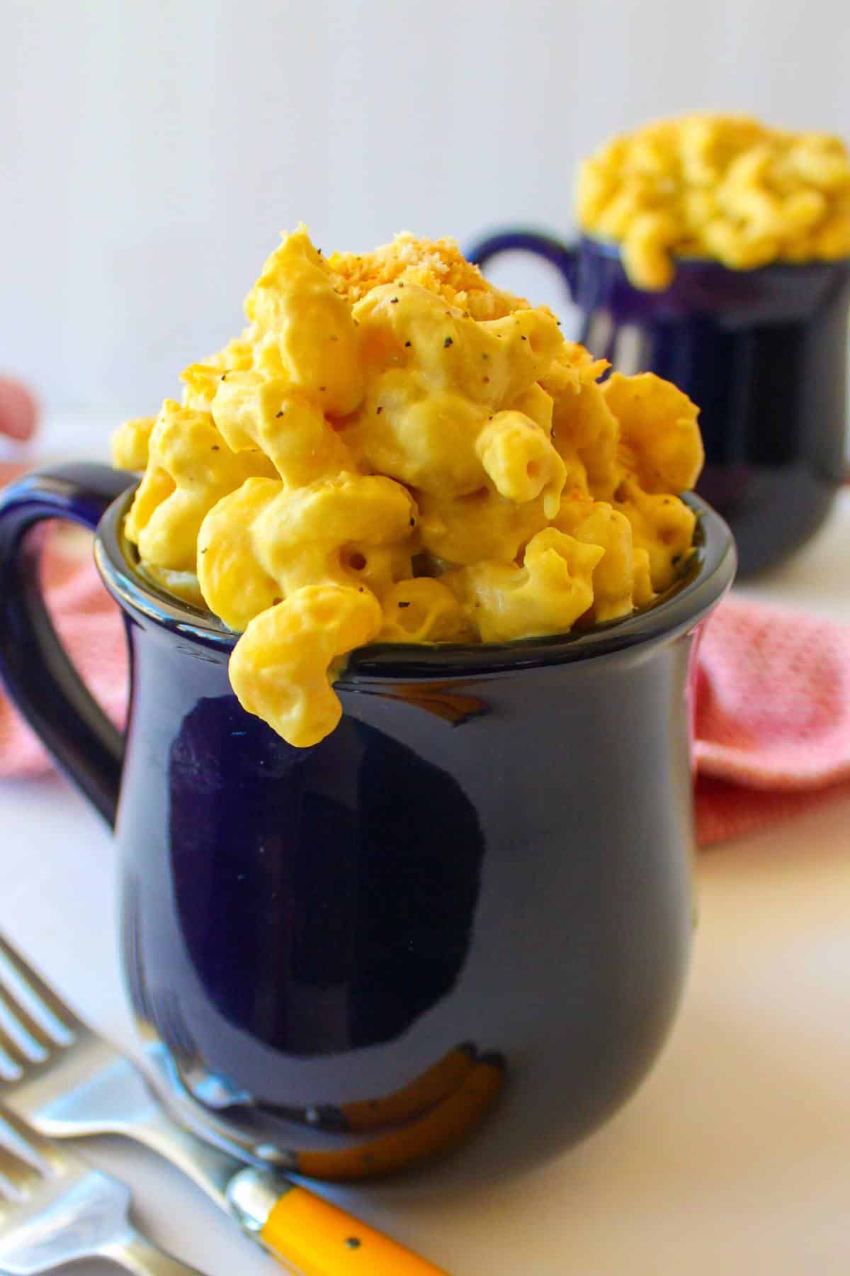 Vegan smoked gouda mac and cheese in a large navy blue mug.