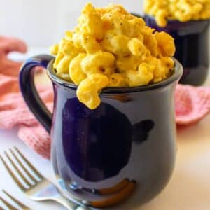 Large navy blue mug full of vegan smoked gouda mac and cheese.