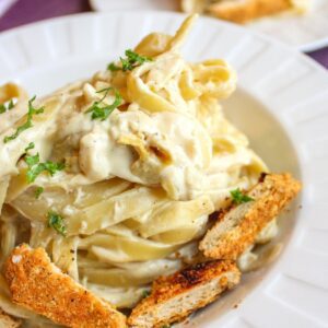 Dairy free alfredo sauce on fettuccini pasta in a bowl with vegan chicken