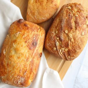 Three loaves of vegan bread on a cutting board