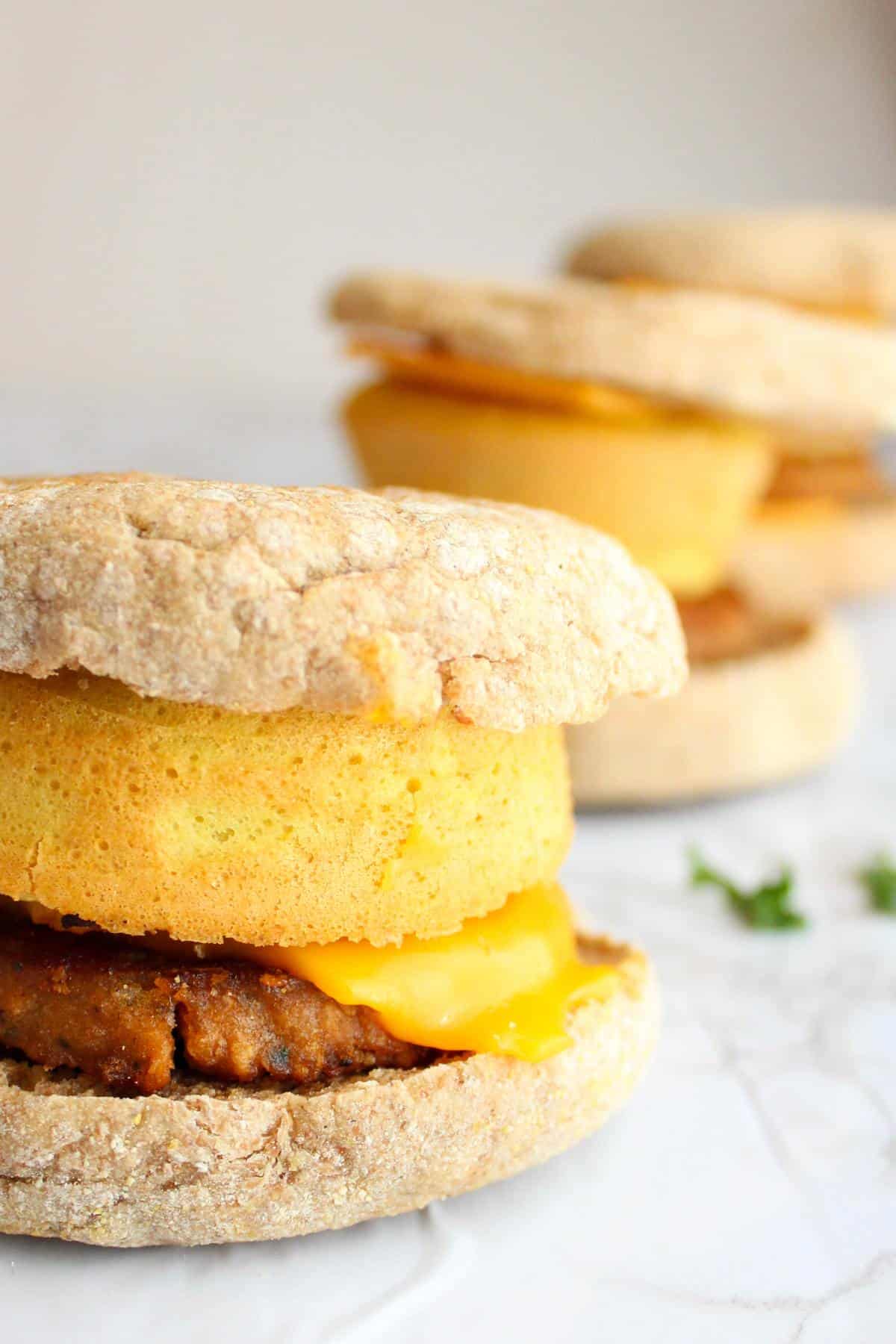 Vegan breakfast sandwiches on a table in a row.