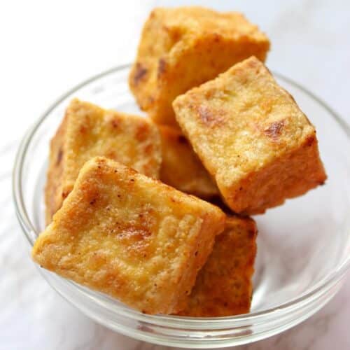 Crispy tofu cubes in a glass bowl.
