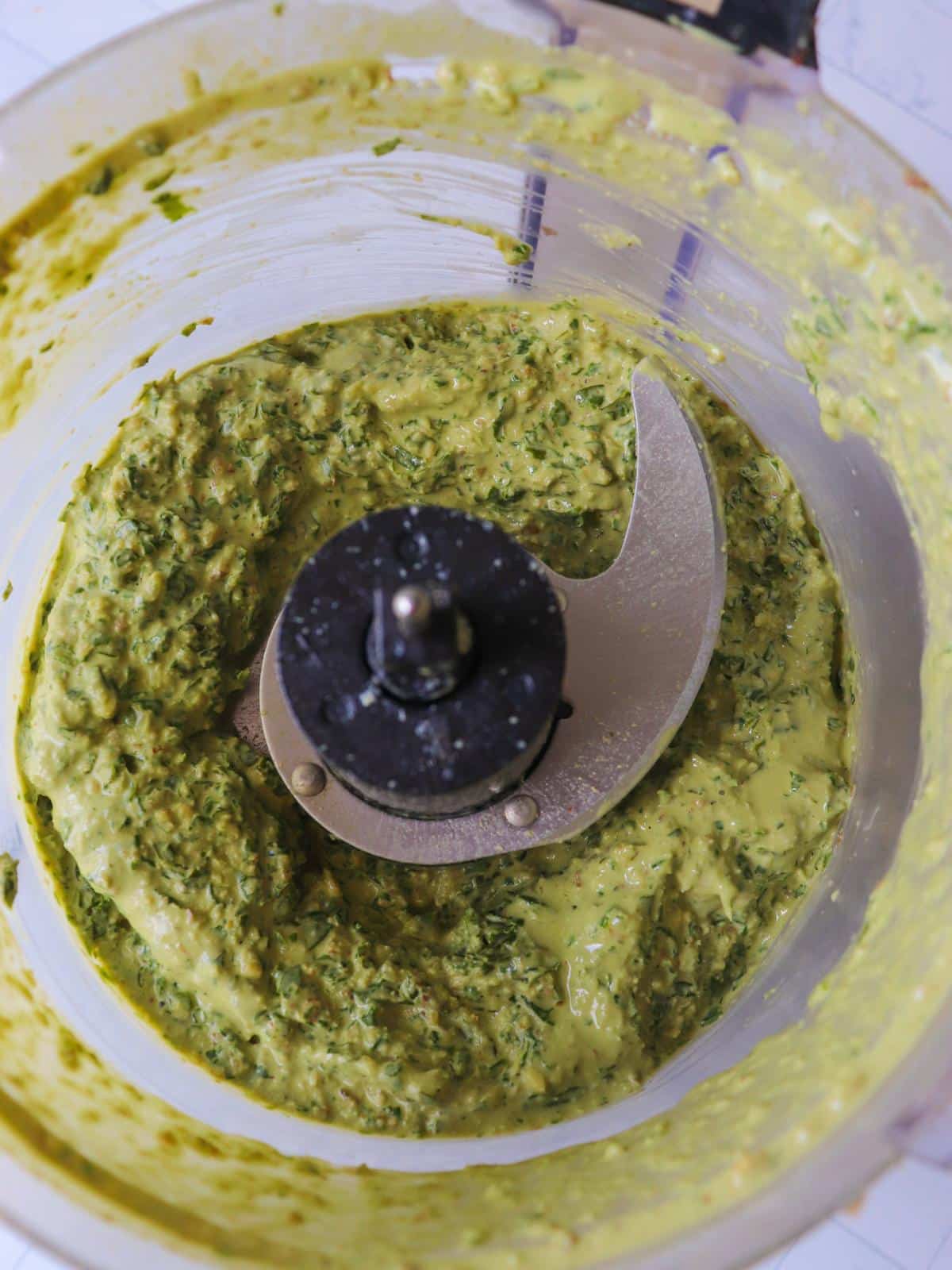 Vegan dairy free pesto blended up in a food processor.