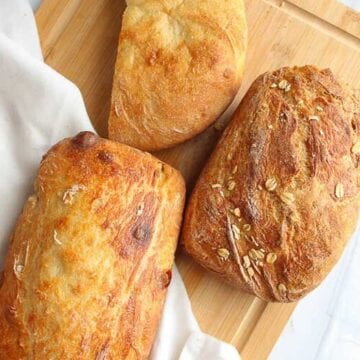 three loaves of vegan bread on a cutting board