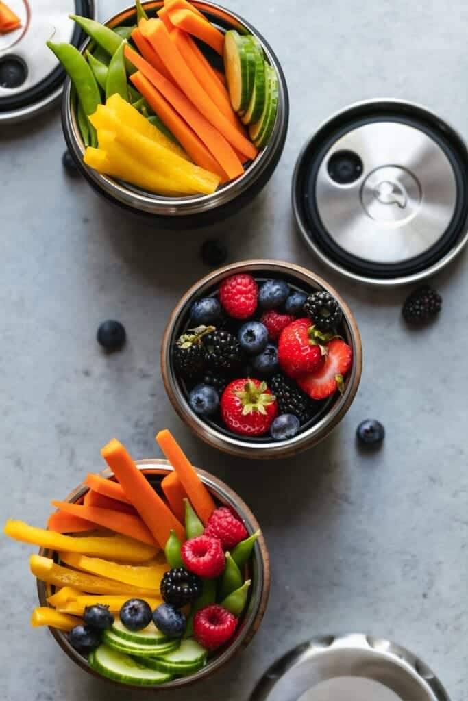 cut up peppers, vegetables and fresh berries in bowls