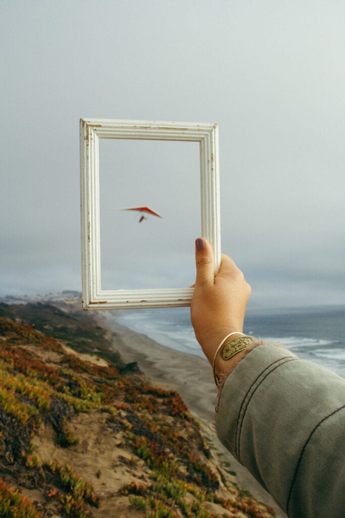 Hand holding a picture frame outside