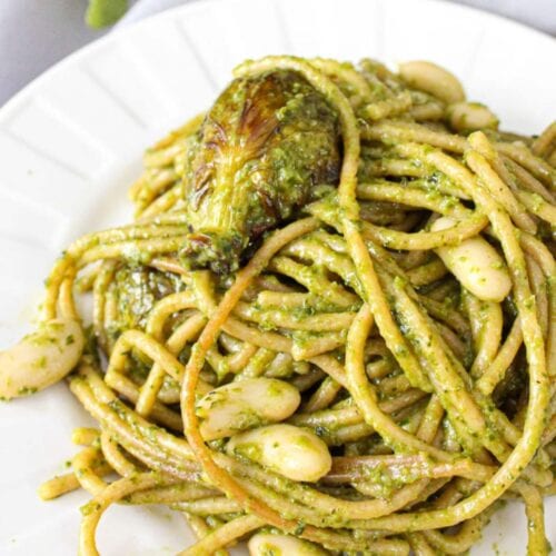 A plate of vegan pesto pasta with roasted vegetables