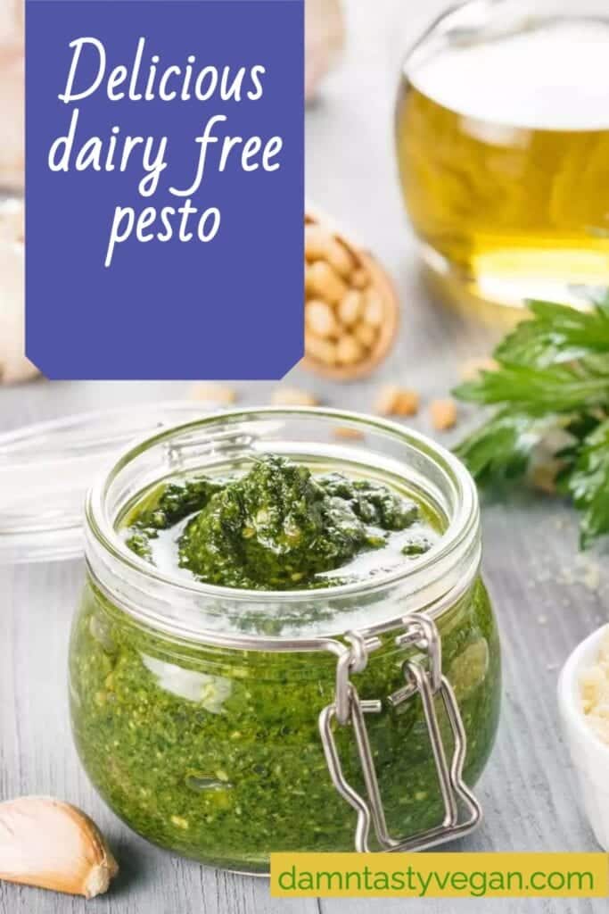 Vegan pesto in a glass jar with ingredients in the background and text overlay for pinterest.