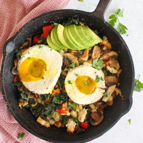 cast iron skillet with vegan breakfast hash and vegan fried egg