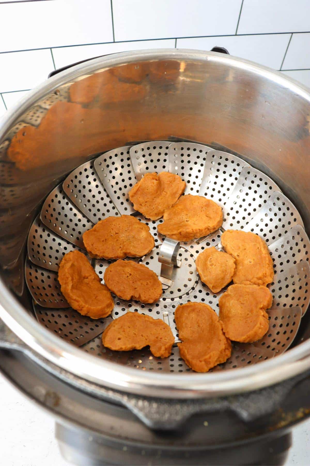 Seitan pieces in a steamer basket in an instant pot.