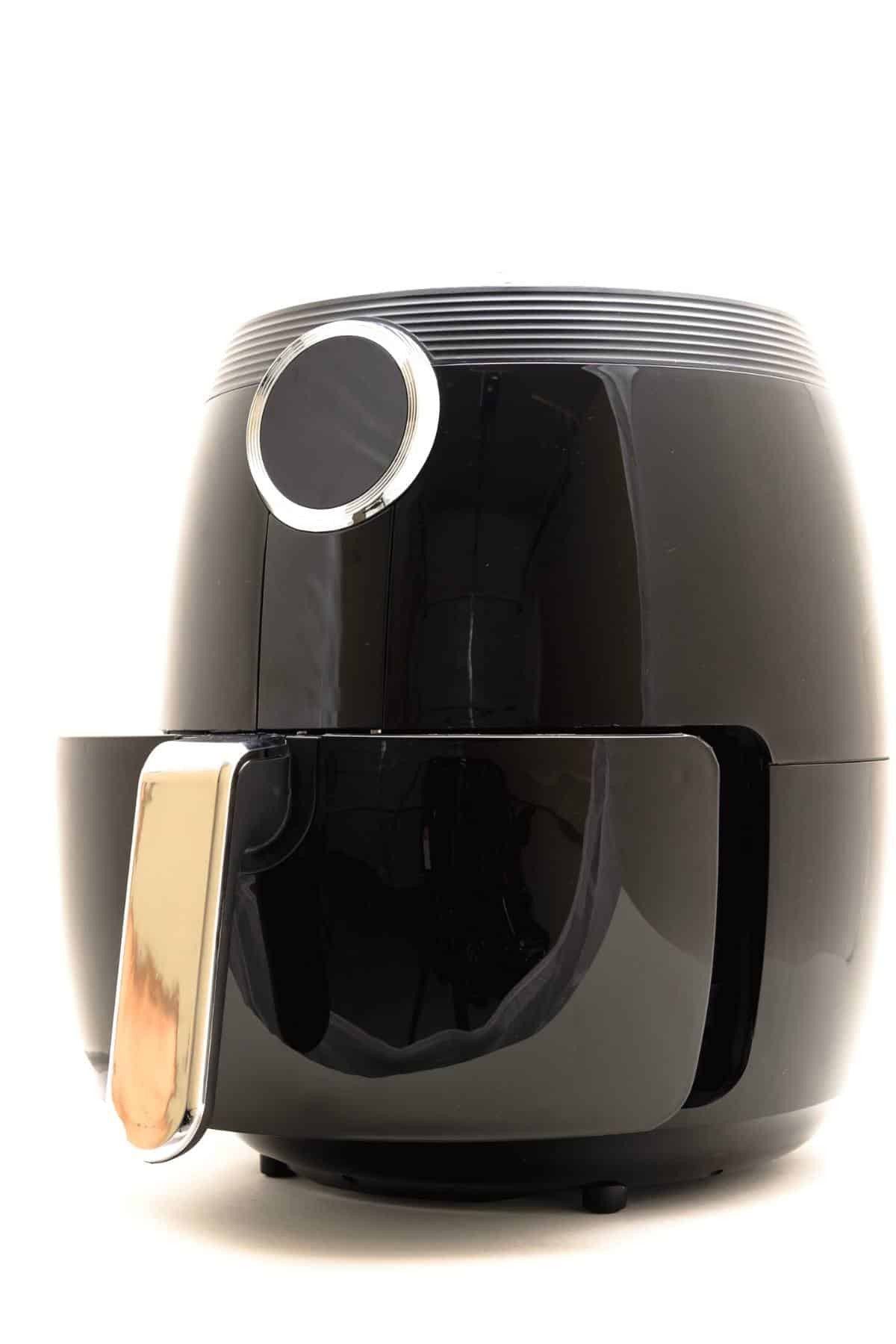 Black air fryer sitting on a counter.