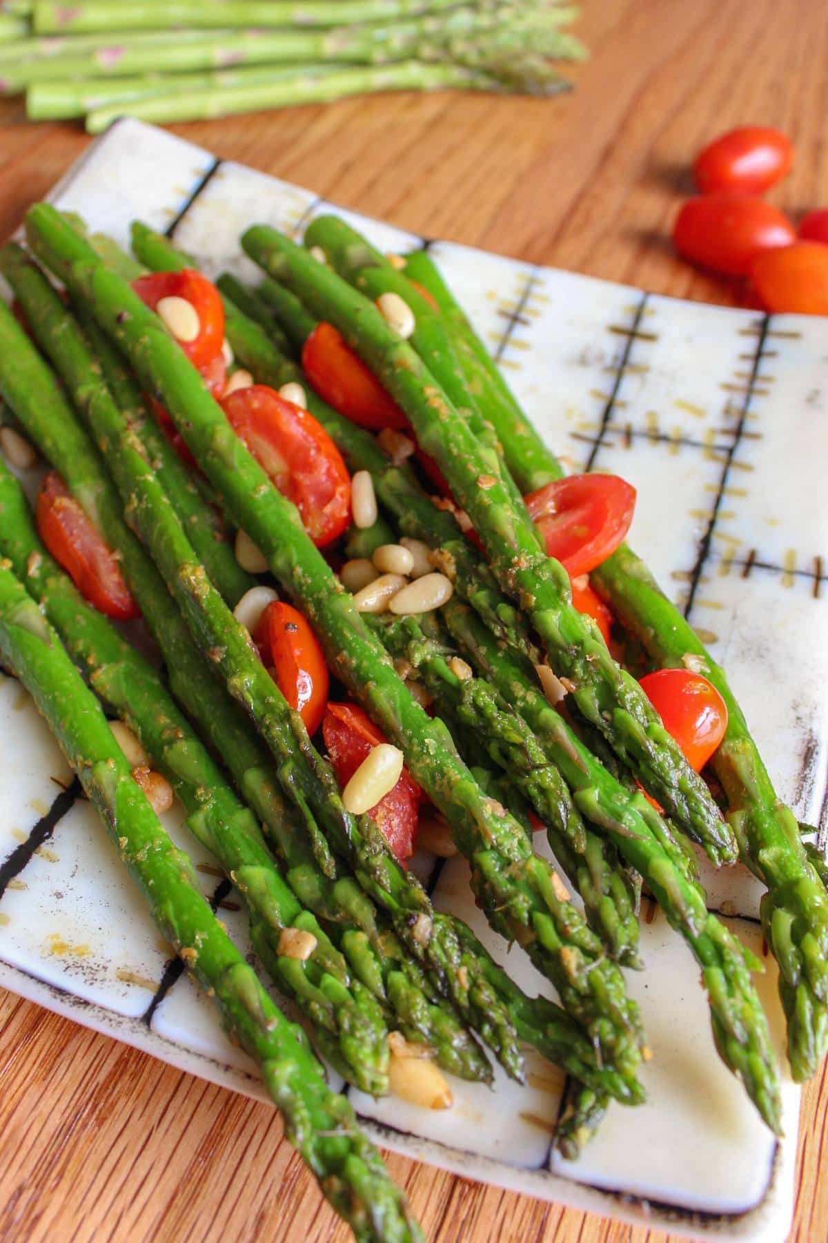 Asparagus, cherry tomatoes and pine nuts on a plate. 