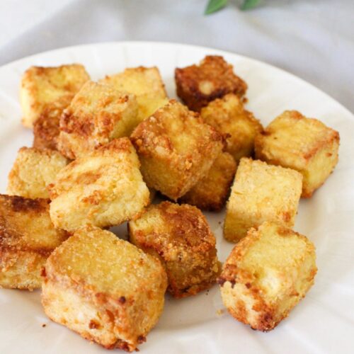 Air fryer tofu cubes on a white plate.
