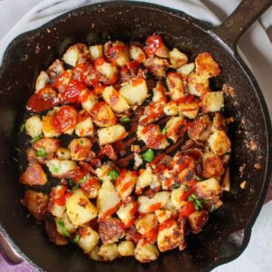 Skillet with crispy breakfast potatoes topped with ketchup