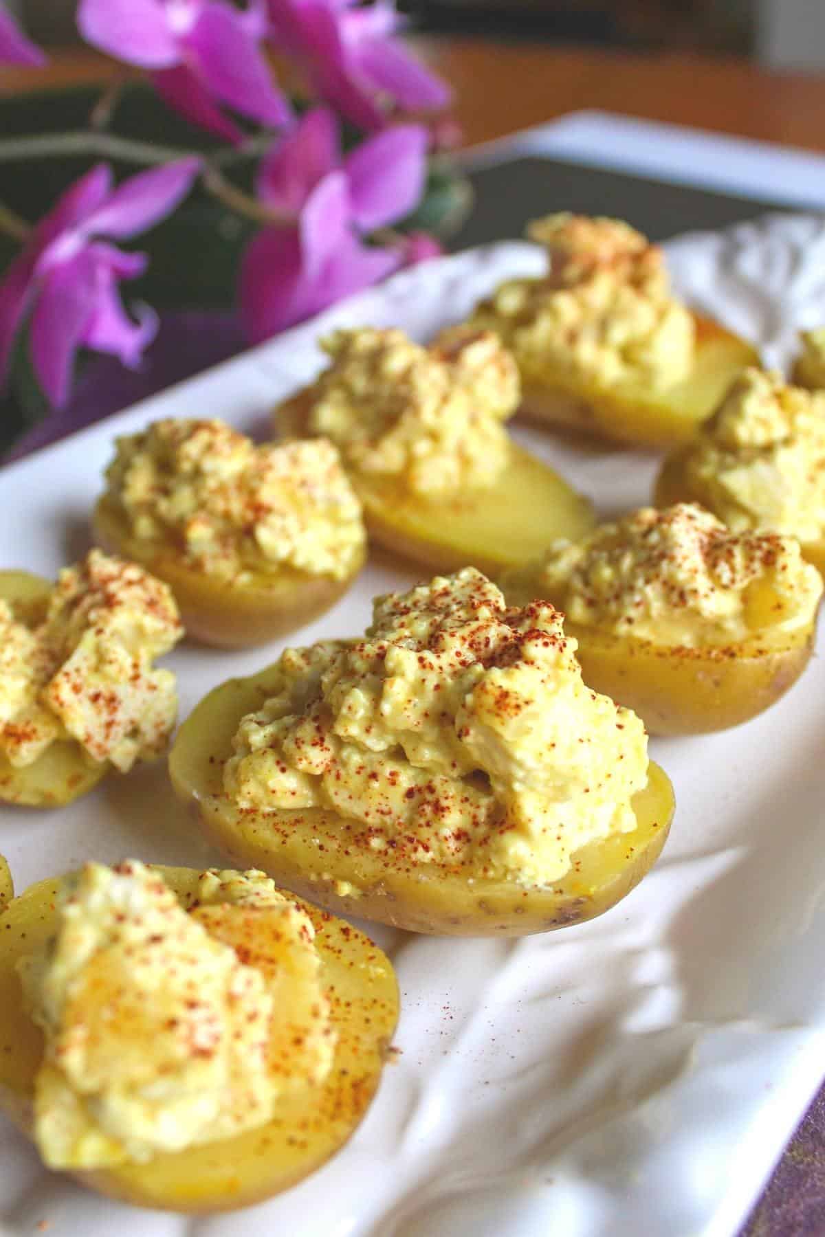 Side view of vegan deviled eggs on a white serving platter