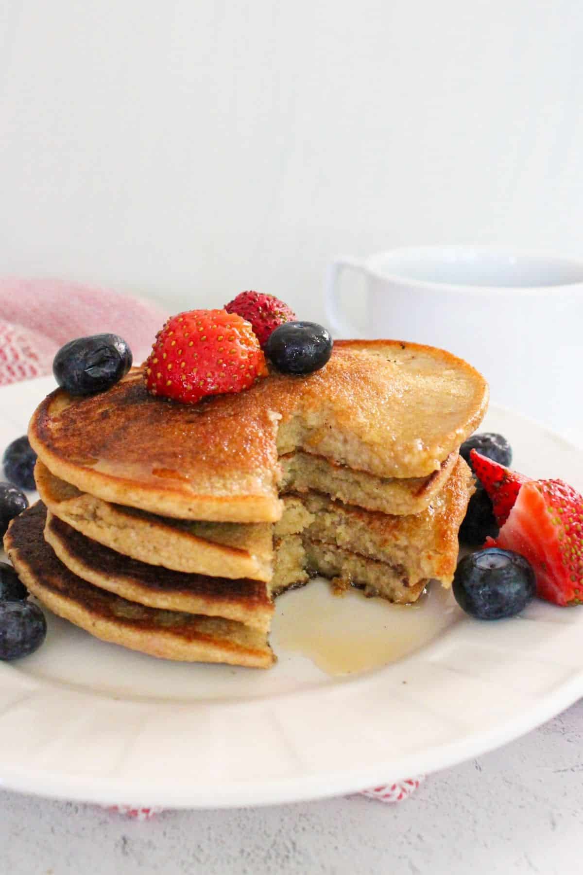 Stack of vegan oatmeal banana pancakes on a plate with fresh berries