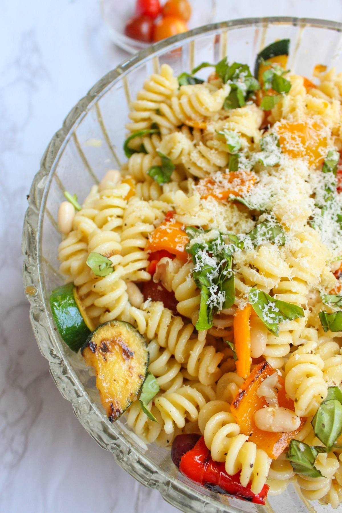 Grilled vegetable pasta salad in a large glass serving bowl. 