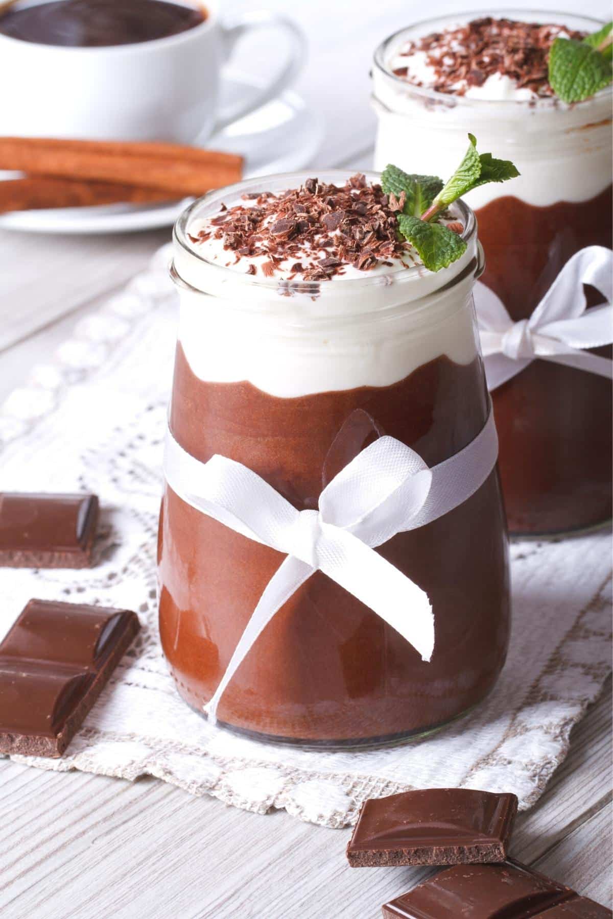 Small glass mason jar filled with eggless chocolate mousse topped with coconut whipped cream