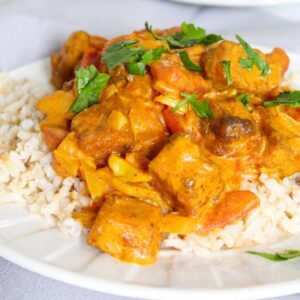 Close up of vegan butter chicken and rice on a plate.