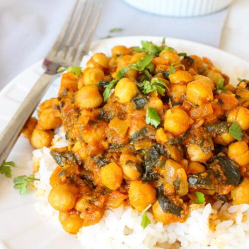 Close up of spinach and chickpea curry on a plate with rice