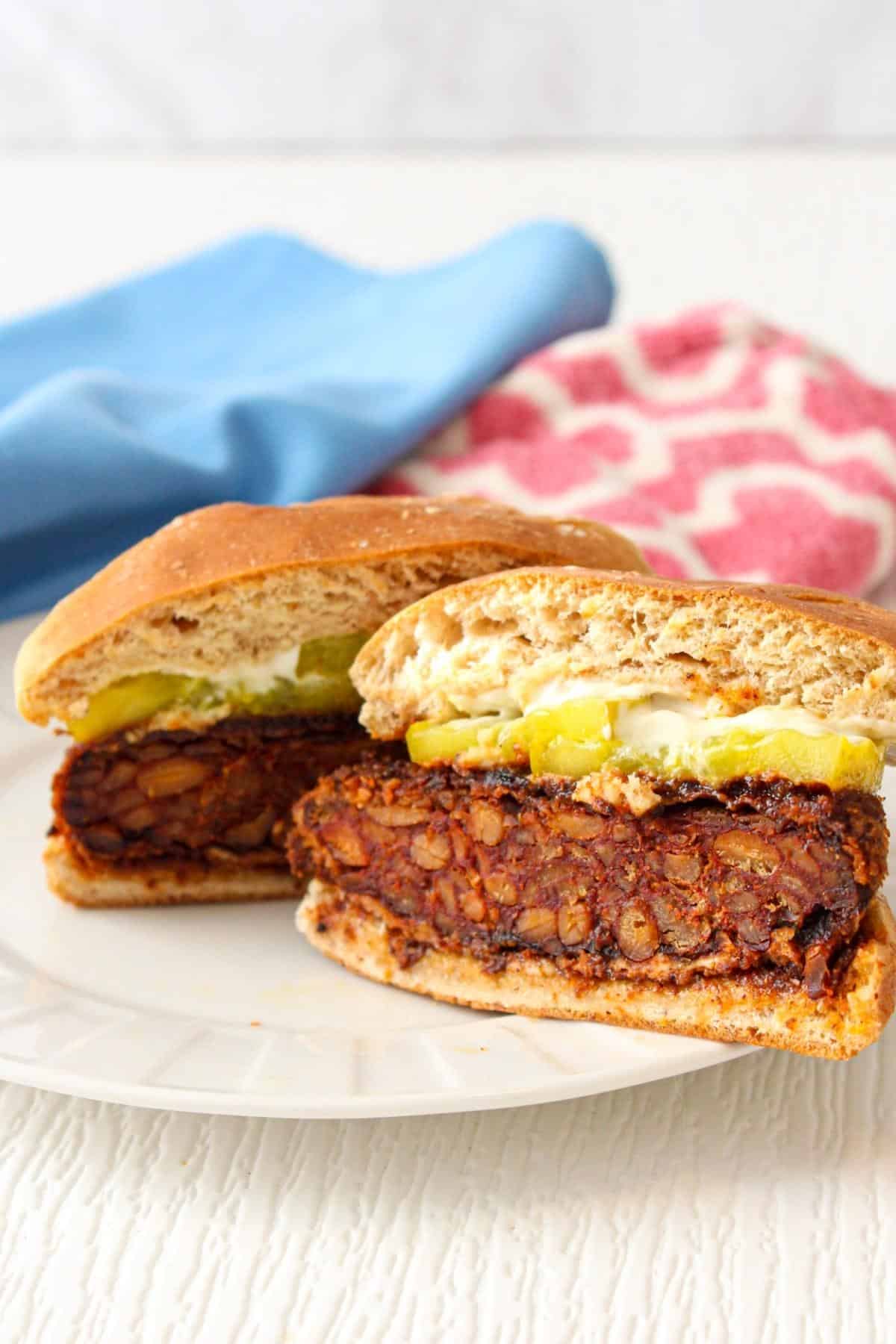 Nashville hot tempeh sandwich cut in half on a plaate