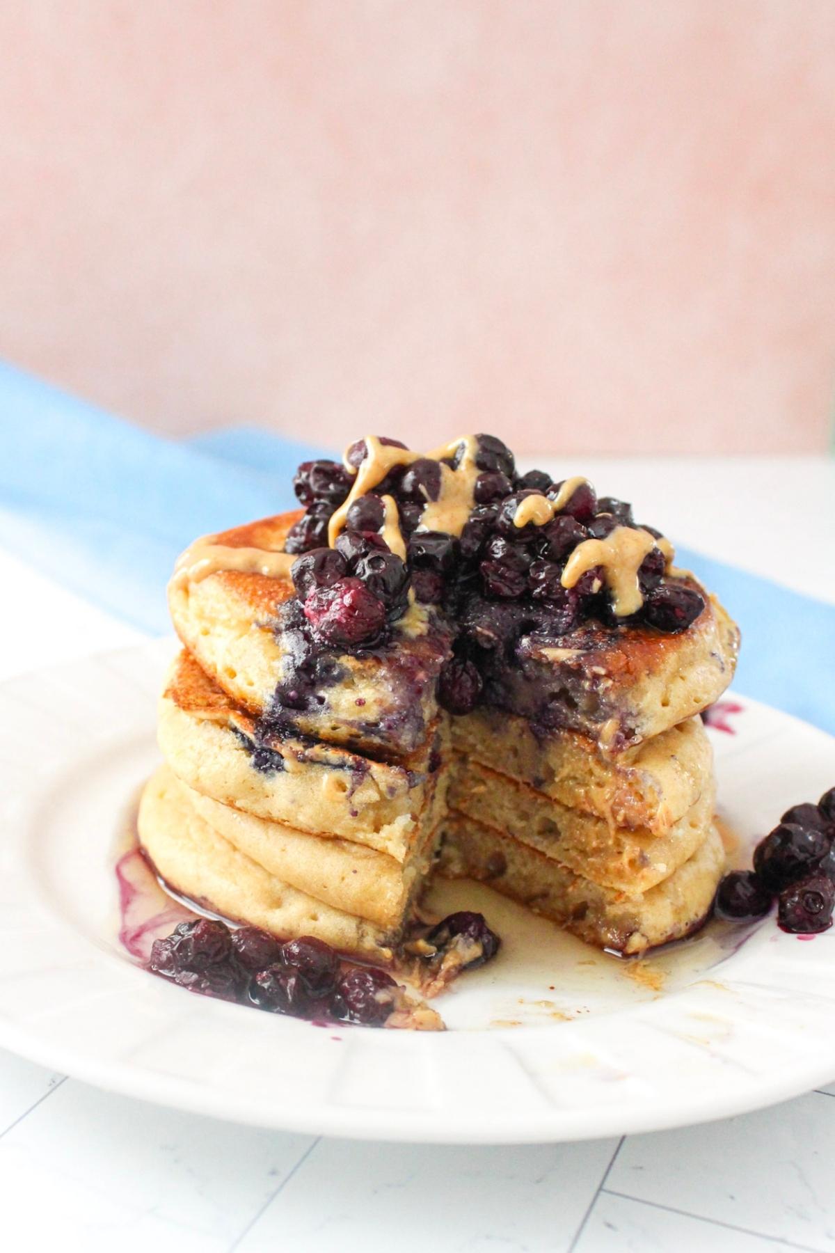 Stack of protein vegan pancakes on a plate topped with blueberries