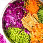 Overhead view of large mixing bowl filled with rainbow salad.