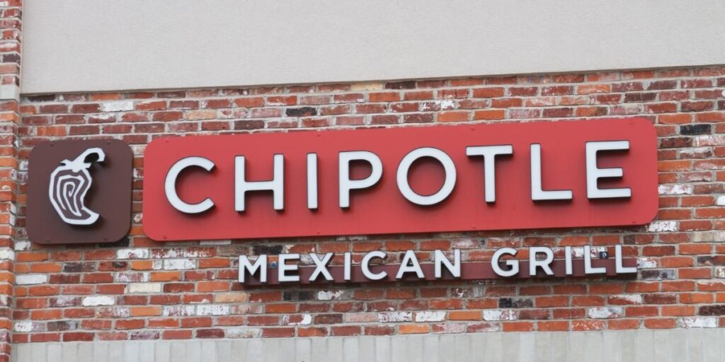 Chipotle sign against a brick wall.