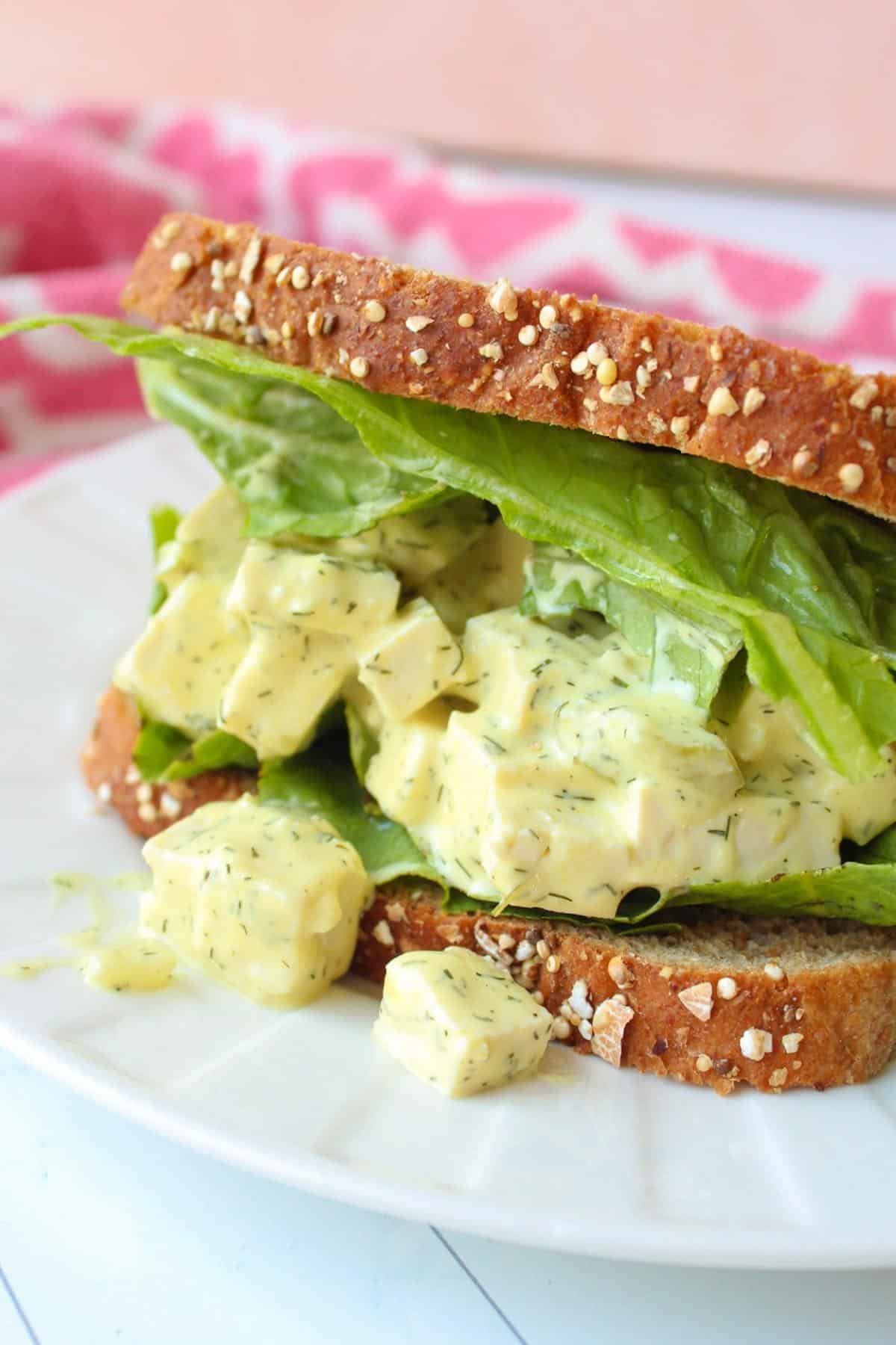Vegan egg salad sandwich on a piece of bread with lettuce