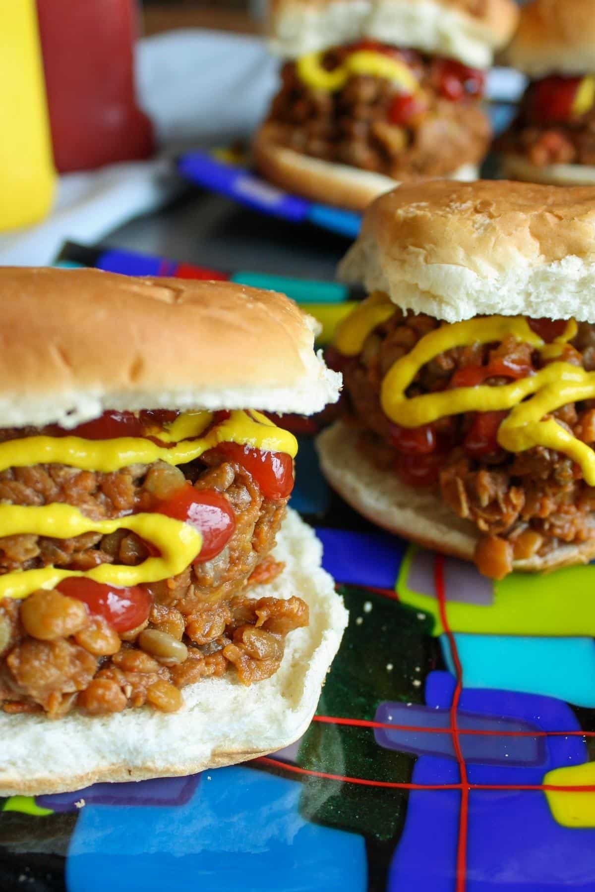 Vegan sloppy joes made with lentils on a hamburger bun on a plate.