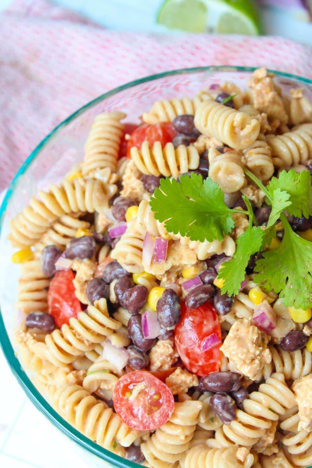 Taco pasta salad in a glass serving bowl topped with cilantro.