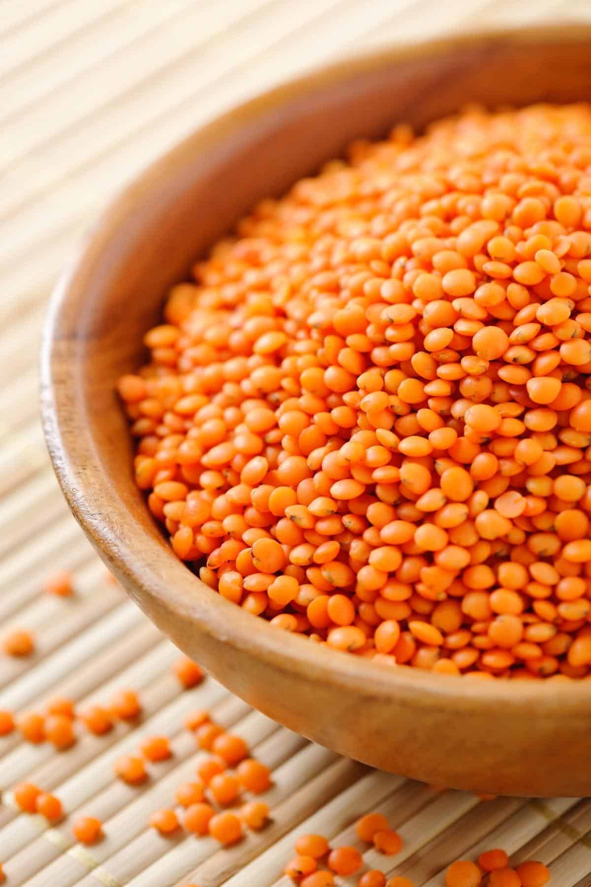 Dry red lentils in a bowl on a table.