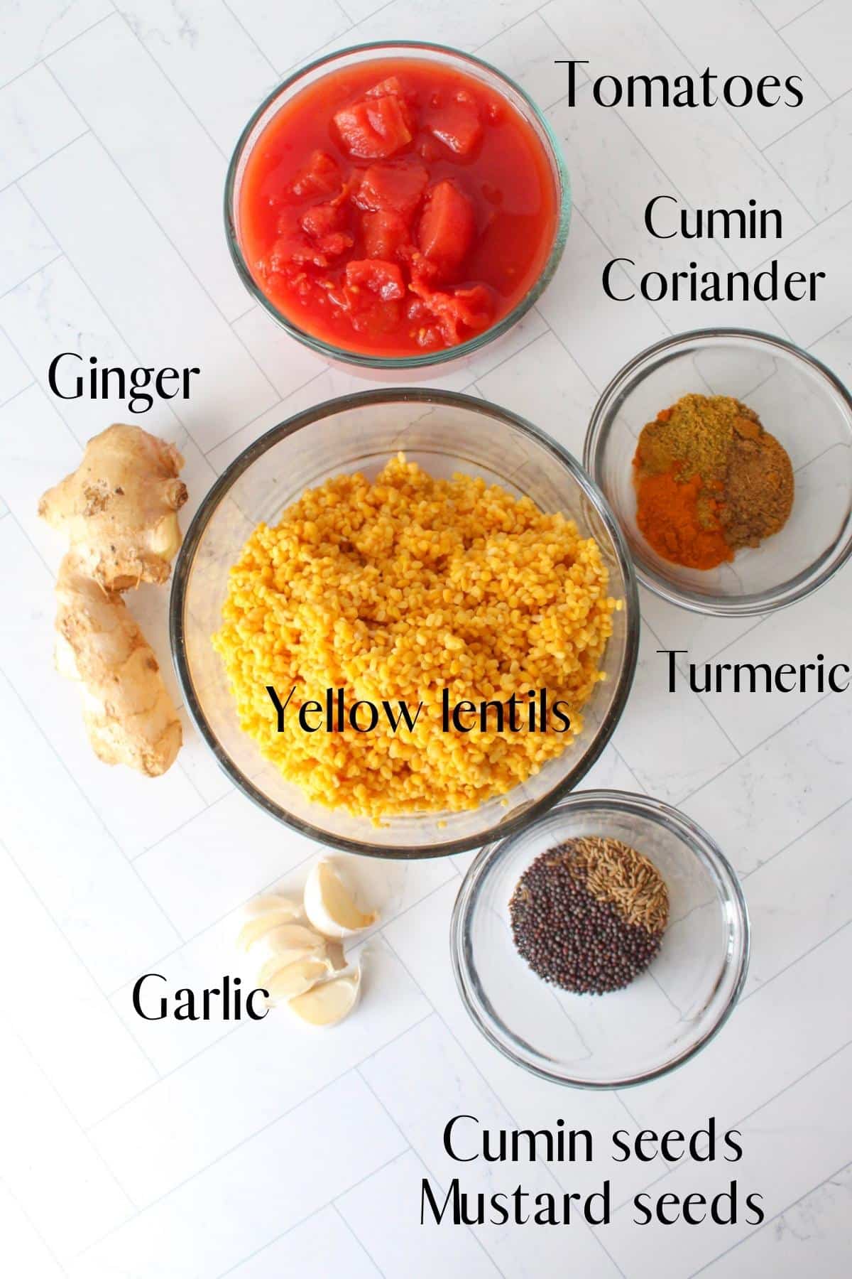 Ingredients for yellow lentil dal laid out in separate dishes