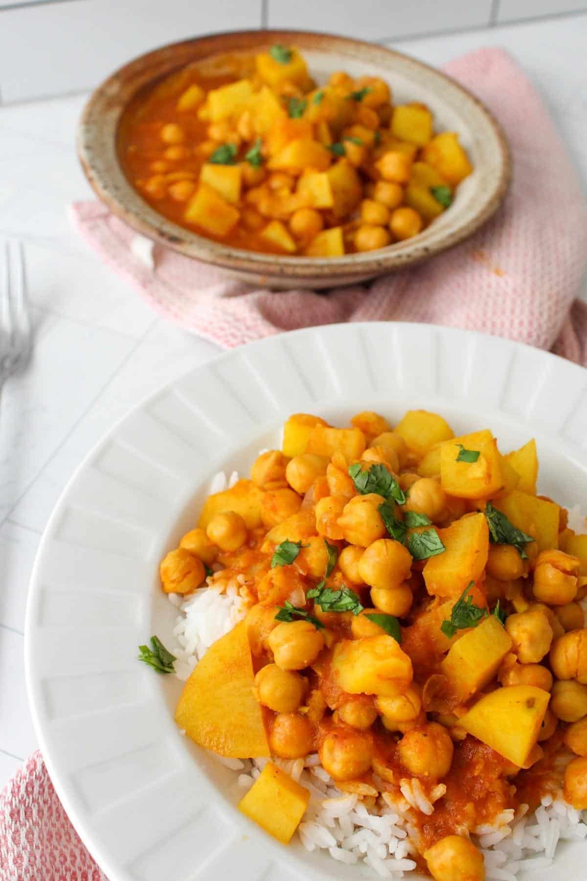 Chickpea and potato curry in a bowl served over rice.