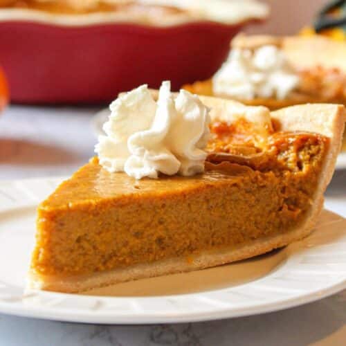 Eggless pumpkin pie on a plate topped with whipped cream