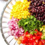 Quinoa black bean salad in a glass serving bowl.