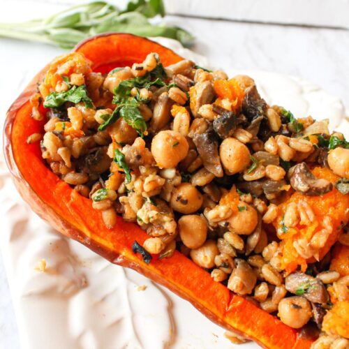 Vegan stuffed butternut squash with farro and chickpeas on a serving dish.