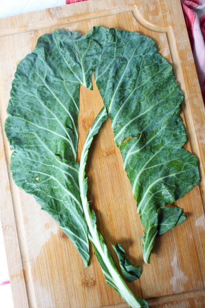 Collard green leaf with stem cut out of the middle.