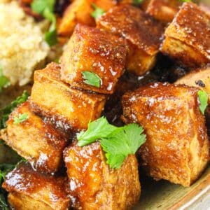 Crispy tofu with peanut sauce in a bowl with quinoa and vegetables.