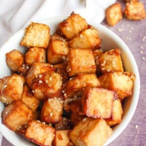 Sesame ginger tofu cubes in a white serving bowl.