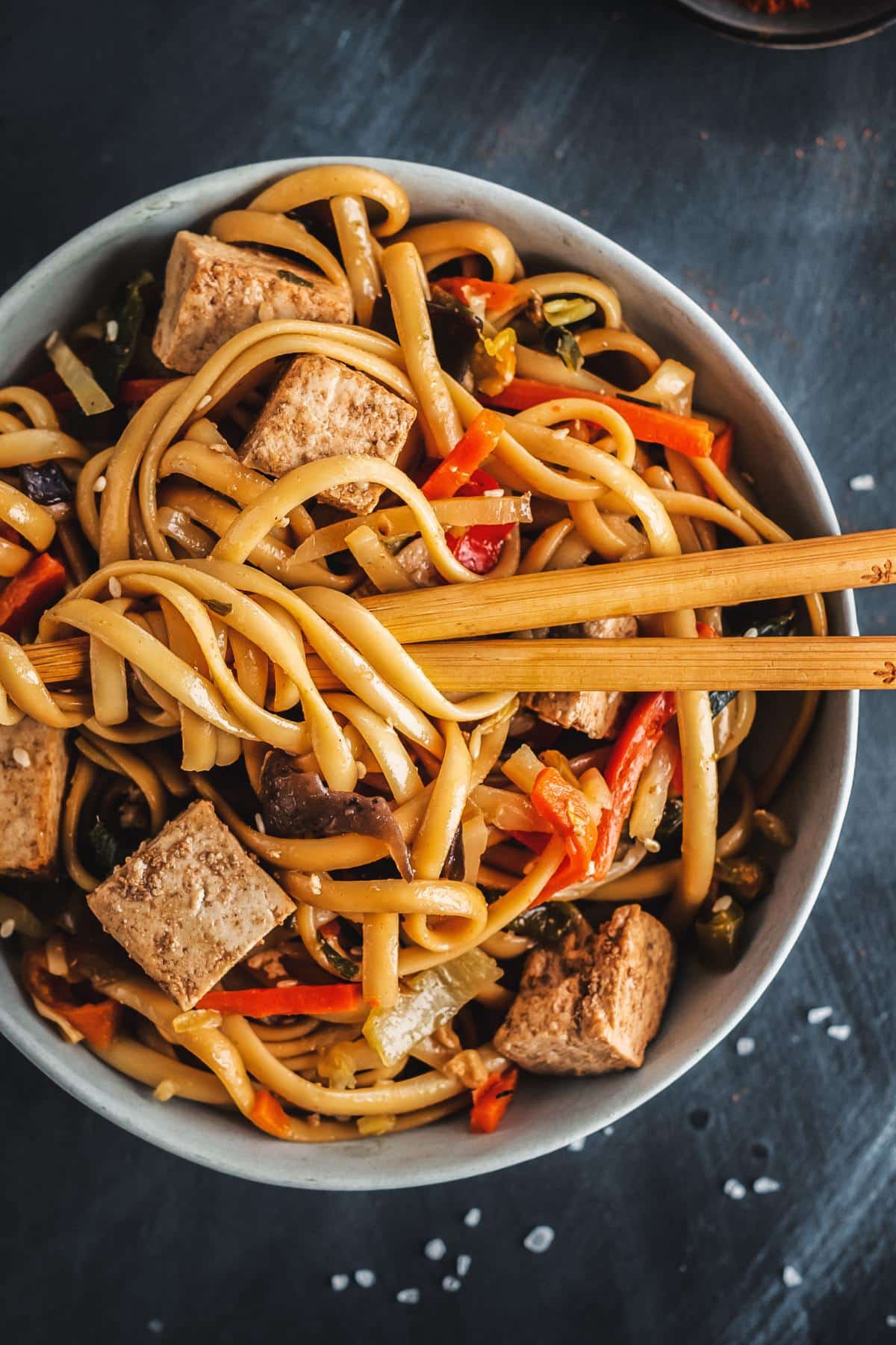 A tofu noodle bowl with chopsticks.