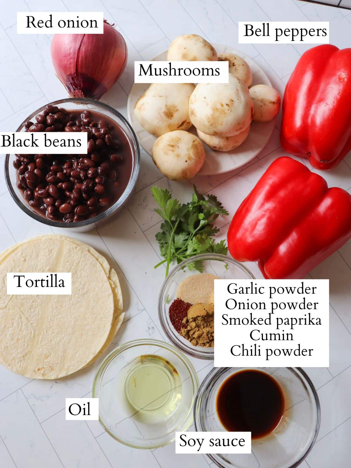 Ingredients for vegetarian black bean fajitas laid out on a kitchen counter.