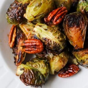 Candied brussel sprouts in a white bowl.