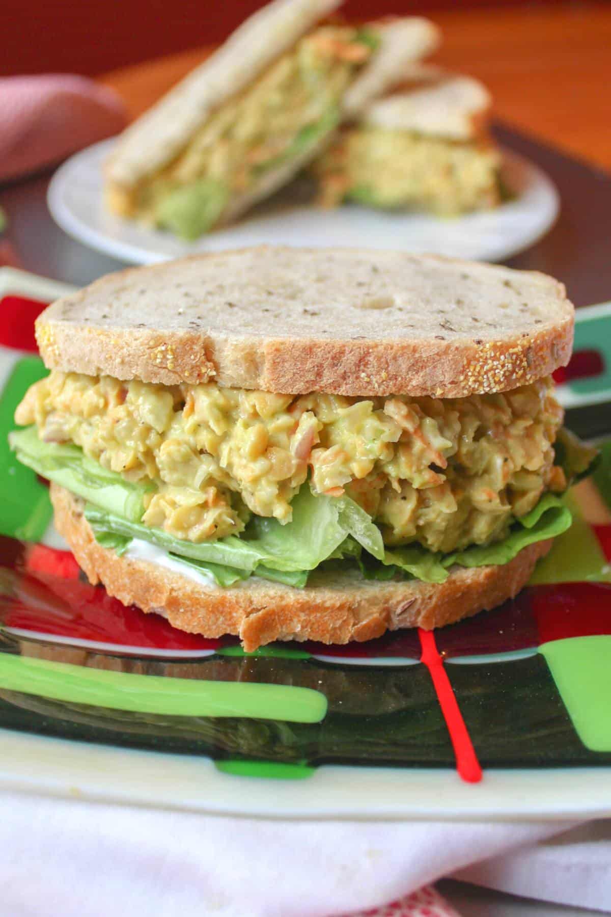 Chickpea salad sandwich on a plate with lettuce.