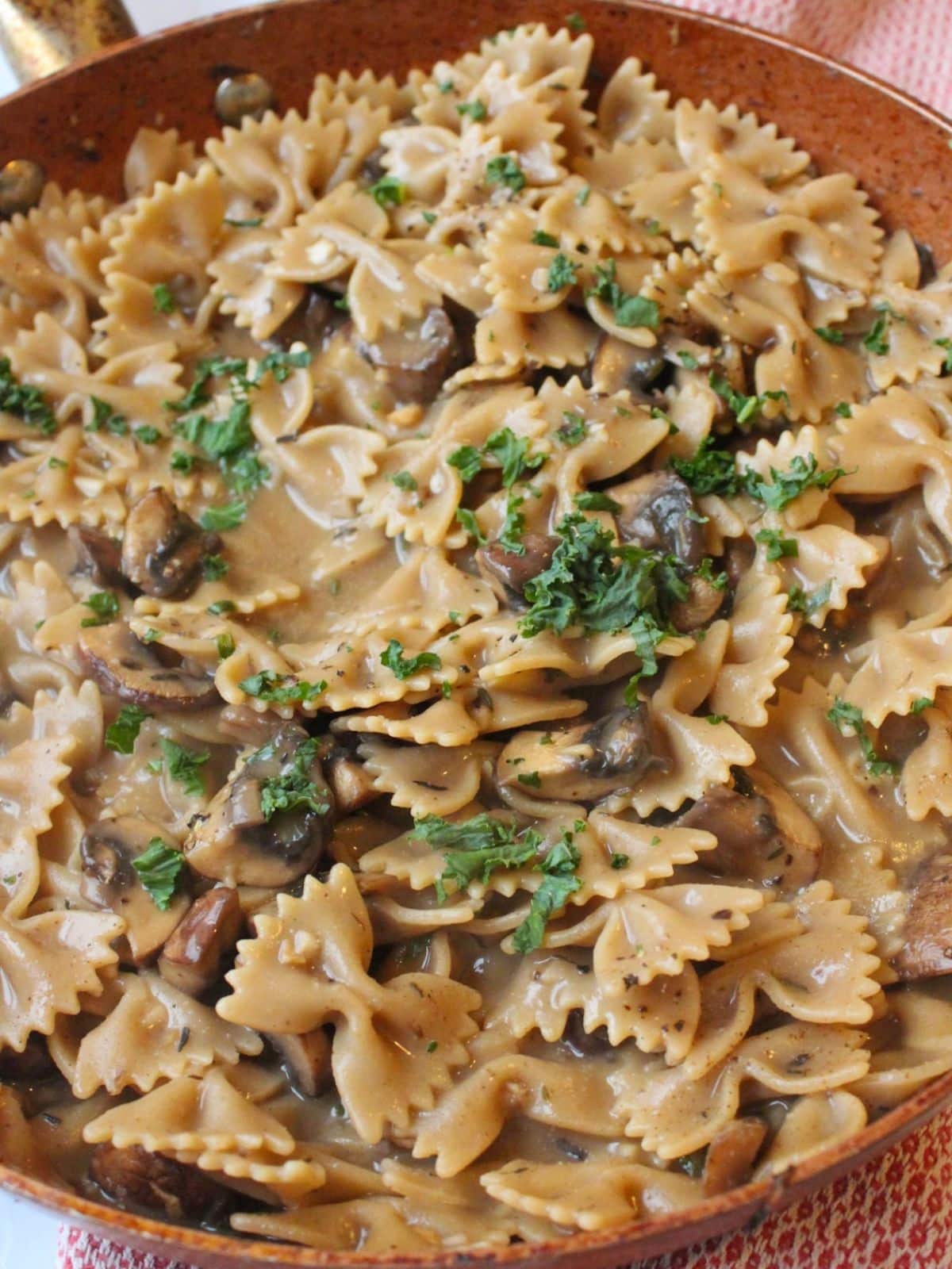 Vegan mushroom stroganoff in a large skillet topped with fresh parsley.