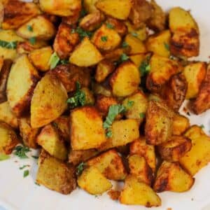 Diced air fryer potatoes on a white plate.