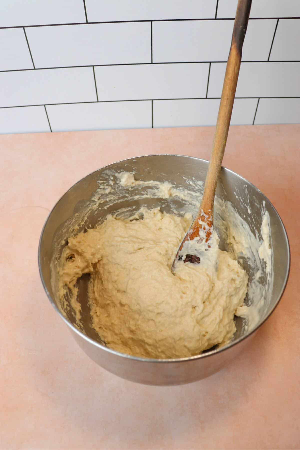 Bread dough in a mixing bowl after adding lukewarm water.